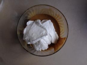 取三分之一打发好的蛋白加入到蛋黄糊里，由下往上翻拌均匀