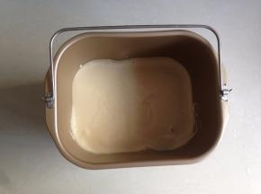 拌好的蛋糕糊倒进面包桶内，轻震几下，以消除内部的气泡