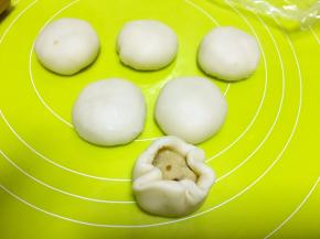 擀成圆片，包裹上豆沙馅，收好收口