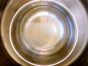 牛奶冻凝固后，做镜面层，取一份吉利丁片用70克冷水泡软，之后加10克砂糖，隔水加热至吉利丁跟砂糖融化，放置一旁凉透备用