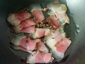 热锅凉油，下花椒小火煸香，下腊肉煸出油脂。