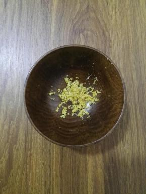 2、用刨丝器将柠檬的外皮擦碎备用。