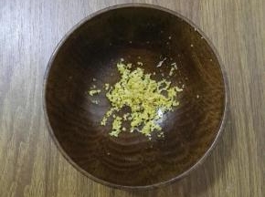 2、用刨丝器将柠檬的外皮擦碎备用。