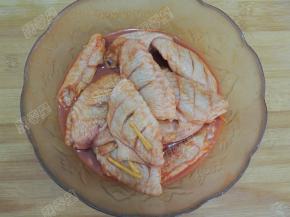 放入鸡翅中搅拌，让鸡翅被调料包裹，盖上保鲜膜腌制四个小时