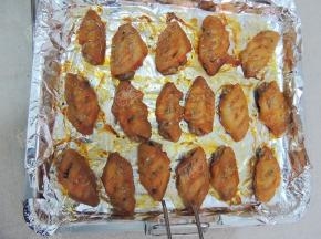 将鸡翅取出，表面刷蜂蜜水，撒上香草