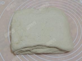 像叠被子一样将面皮右边向中间叠过来，左边再叠过去，边缘合好，完成三折然后由下往上对折