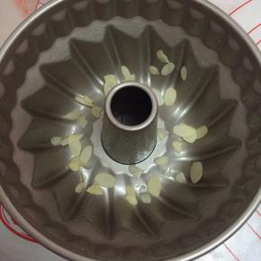 把模具涂上薄薄一层黄油，放入杏仁片备用。