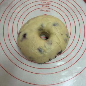 将发酵完成的面团排气，滚圆。中间戳个洞，放入模具中。