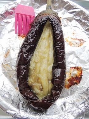 烤好的茄子取出，分开中间那道口子，用筷子将茄子挑松