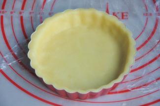 将面皮铺入5寸的派盘，四周贴合，多余的面皮用擀面棍擀掉。