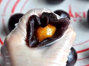 用豆沙把蛋黄包住，搓成圆球。