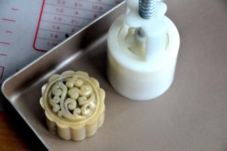 将包好的月饼放入50克的月饼模中，轻轻一压，月饼的雏形就有了。