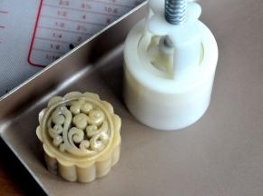 将包好的月饼放入50克的月饼模中，轻轻一压，月饼的雏形就有了。