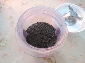 将黑芝麻分次放入料理机干磨杯中磨碎