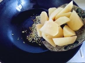 加入切好的土豆块翻炒，炒至微黄，盛出备用。