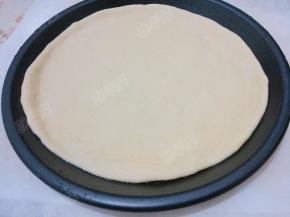 饼坯放入披萨盘中，把饼边捏好