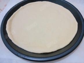 饼坯放入披萨盘中，把饼边捏好