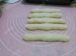 取一个剂子擀成长舌形，从上部向下卷起，接口处捏紧