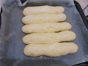 饧发到面包坯子原体积2-3倍大，用刷子把蛋黄液刷在面包生坯表面