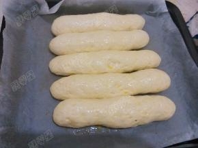 饧发到面包坯子原体积2-3倍大，用刷子把蛋黄液刷在面包生坯表面