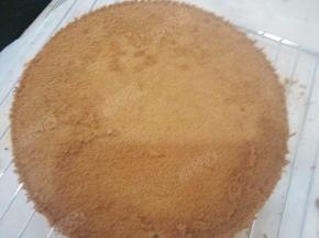 蛋糕出炉后，立刻倒扣在烤架上晾凉，完全凉透后，用小刀沿着边缘划一圈脱模，底部也用小刀贴着划一圈，脱模后用手拍掉蛋糕表面的碎屑