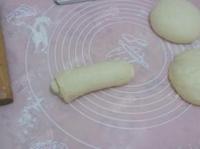 取一个静置好的面团卷，擀成长条，宽度不要超过吐司模的宽度，自上而下的卷成卷，一定要卷紧