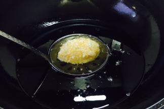 
当油温4成热时把一个裹满面包糠的土豆放入油锅里，此时把火调到中小火。 注意，土豆在还没有定形时不要随意翻动。