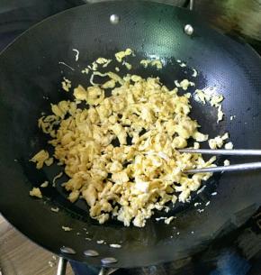 把鸡蛋放入锅中炒成小块，盛出备用。