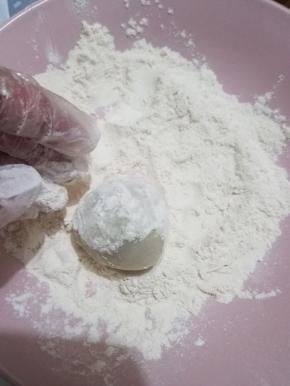 包好的圆球放入糕粉内轻轻的滚一圈，放入模具内，刮板盖住，倒扣在面板上，用力速度按压三下，然后轻轻的抬起模具，一个简单的月饼就完成了，然后用羊毛刷刷掉表面的糕粉就可以了。