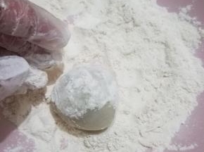 包好的圆球放入糕粉内轻轻的滚一圈，放入模具内，刮板盖住，倒扣在面板上，用力速度按压三下，然后轻轻的抬起模具，一个简单的月饼就完成了，然后用羊毛刷刷掉表面的糕粉就可以了。