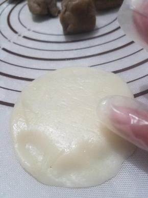 取一个面团压扁，边缘用手捏薄一点，然后像包包子一样把馅料包进去，封好口。（其余没用的面团记得用保鲜袋或者保鲜膜包好）