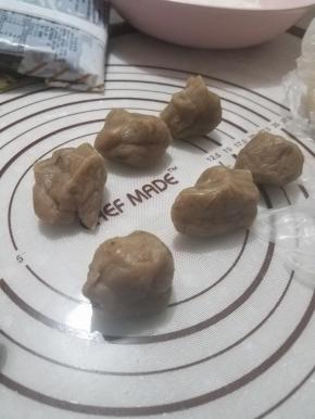 然后把栗蓉馅料倒出，用手掌简单的搓一下，颜色微微变浅即可，每份25g搓圆。