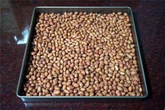 烤箱上下火150度预热，将带皮花生倒入方形烤盘中，放入预热好的烤箱中层，烘20分钟，取出。