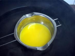 熬糖浆的时候，烧一锅热水，同时隔水融化黄油，备用。去皮花生也可以放入烤箱烤几分钟，温热备用。