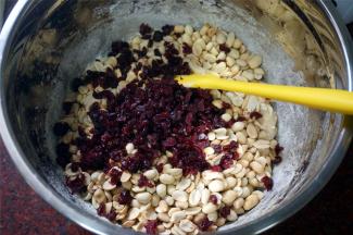 加入温热的花生，放入蔓越莓干，戴上手套，将材料揉均匀。