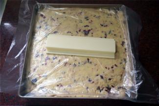 将糖倒入不粘方盘中整形。表面盖上保鲜膜，然后用小擀面杖压紧或借助其他工具压平整（我用的是寿司模具压糖）。