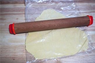 将面团装入大号加厚的保鲜袋中，然后擀成0.3厘米厚的薄片。