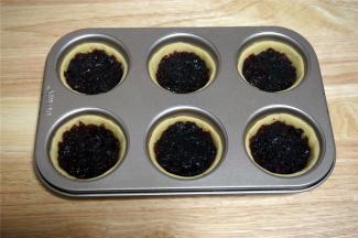 将蔓越莓馅料平均分配到6个饼坯托中，并将馅料抹平。