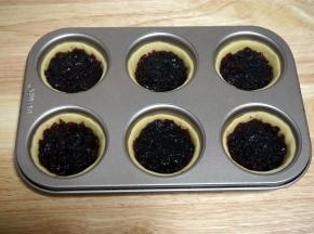 将蔓越莓馅料平均分配到6个饼坯托中，并将馅料抹平。