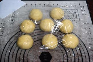 将面团排气后称重，然后平均分成8份，揉圆，盖上保鲜膜，松弛20分钟。