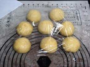 将面团排气后称重，然后平均分成8份，揉圆，盖上保鲜膜，松弛20分钟。