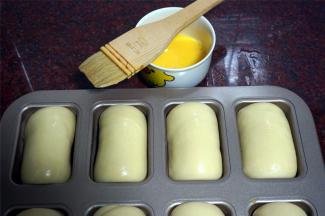 上火180度，下火170度预热烤箱，同时给发酵好的面包坯刷上一层全蛋液。