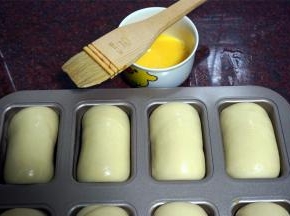 上火180度，下火170度预热烤箱，同时给发酵好的面包坯刷上一层全蛋液。