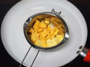 饼干冷却的过程，准备馅料。将巧克力和黄油切成小块，隔水融化后装入裱花袋里。