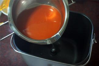 榨取新鲜的胡萝卜汁，取120毫升加入到面包机桶里。