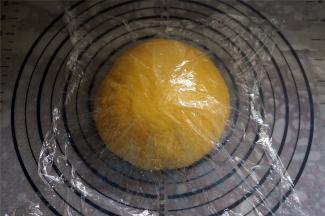 取出面团，排气，然后揉圆，盖上保鲜膜，松弛15分钟。