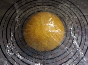 取出面团，排气，然后揉圆，盖上保鲜膜，松弛15分钟。