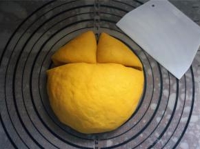 在面团三分之一处切一刀，然后将小面团再分成两份，如图。