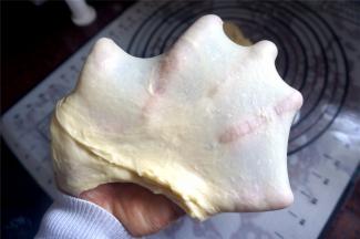 将主料的食材按照先液体后固体的顺序放入面包机内（黄油除外），一共启动两次揉面程序，在第一次揉面程序结束后放入黄油粒。将面团揉至出膜状态。