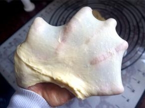 将主料的食材按照先液体后固体的顺序放入面包机内（黄油除外），一共启动两次揉面程序，在第一次揉面程序结束后放入黄油粒。将面团揉至出膜状态。